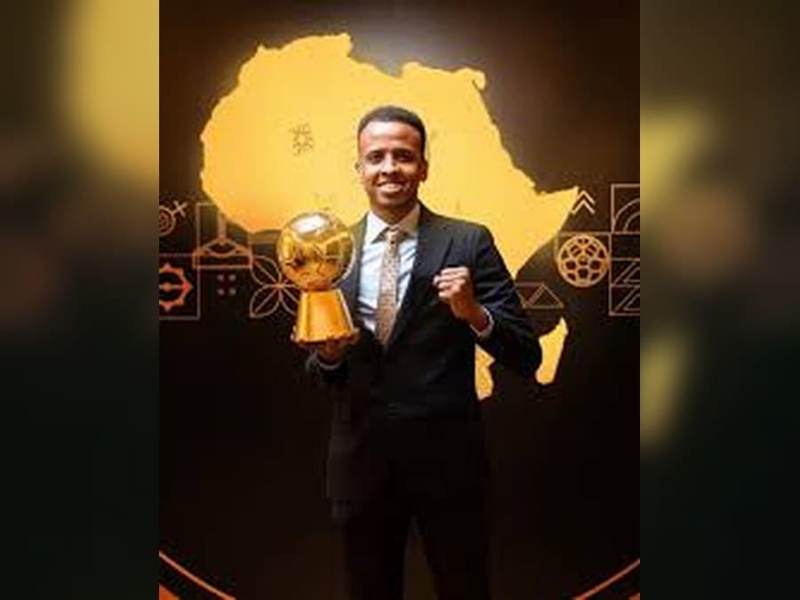 Omar Artan holding a football award