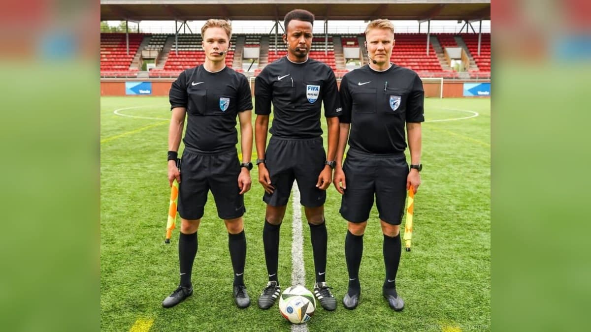 Omar Artan standing with fellow match officials