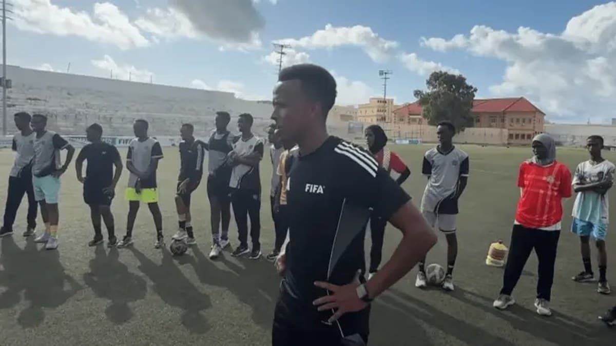 Omar Artan training young footballers and officials on the pitch